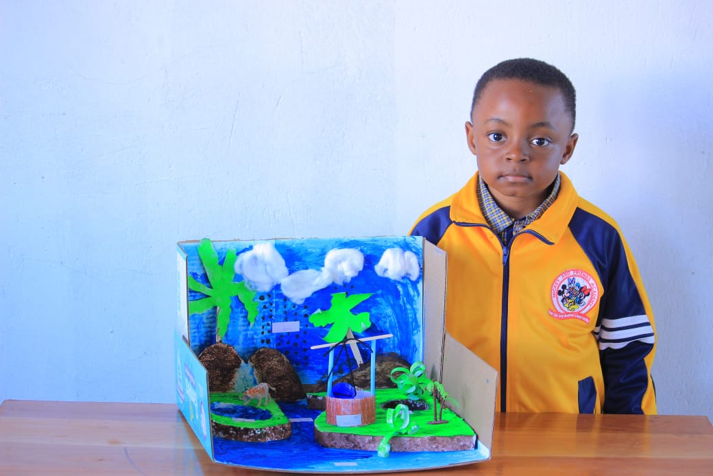Boy standing beside his water cycle island model