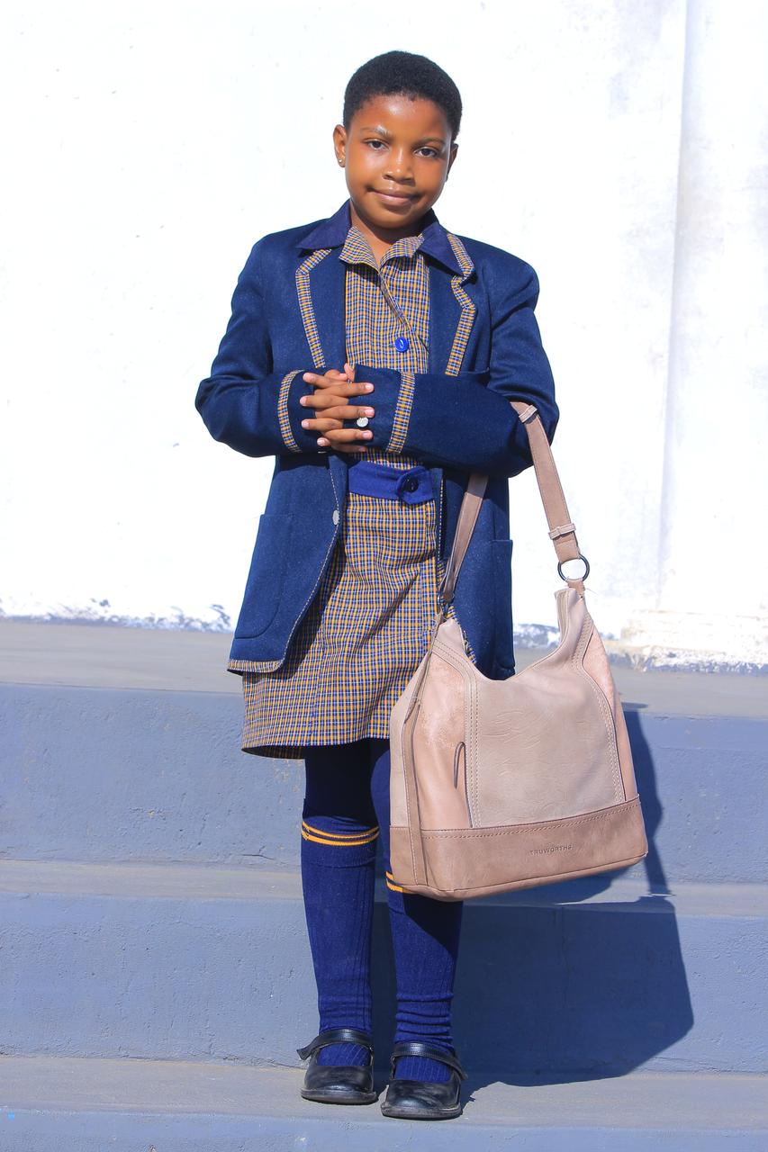 Learner in winter uniform holding a handmade shoulder bag