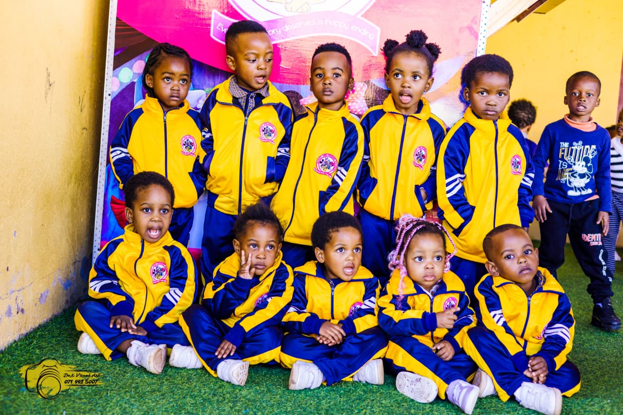Creche class in navy and yellow tracksuits posing after the puppet show