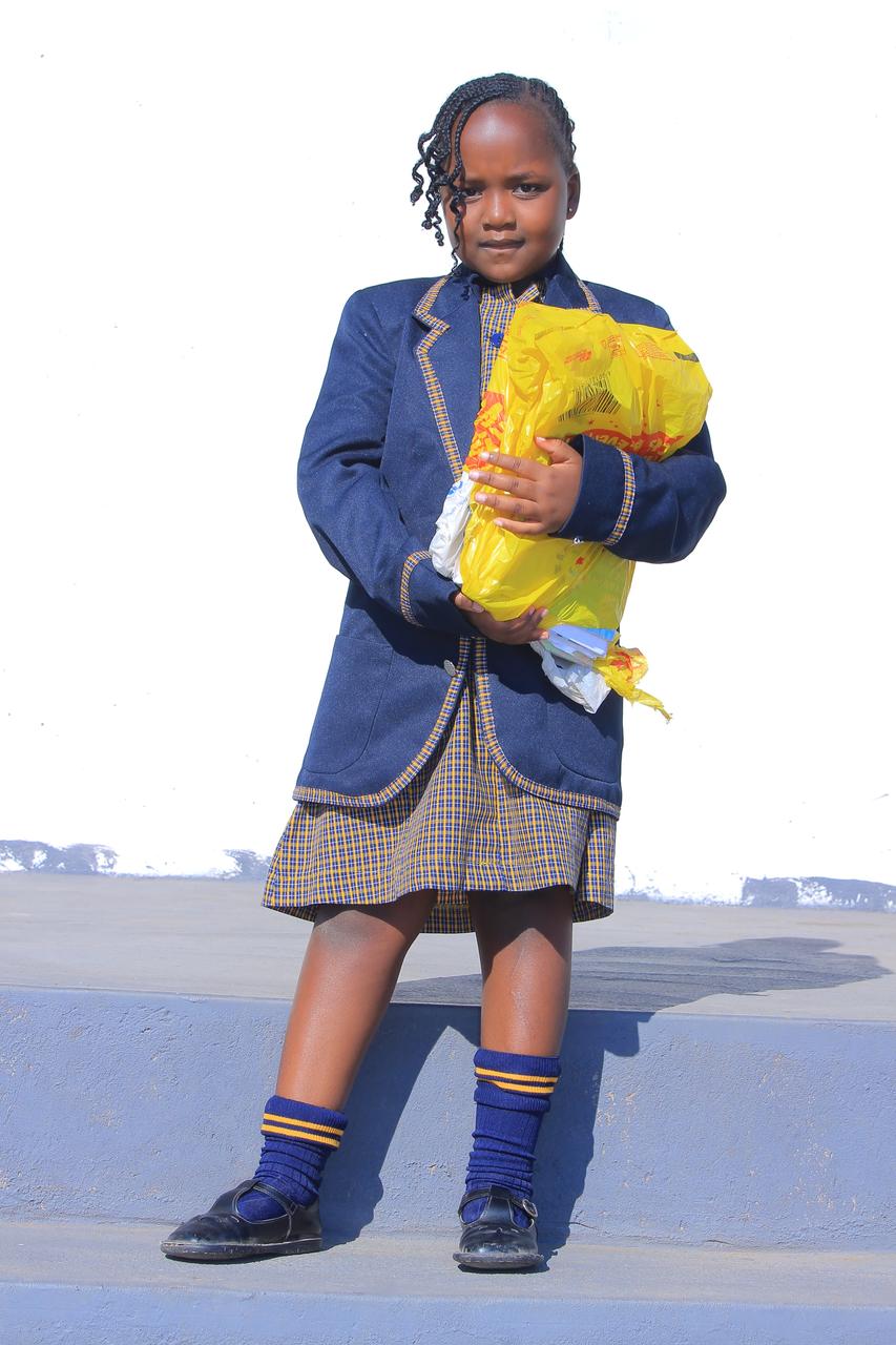 Girl in blazer carrying a colourful recycled plastic bag