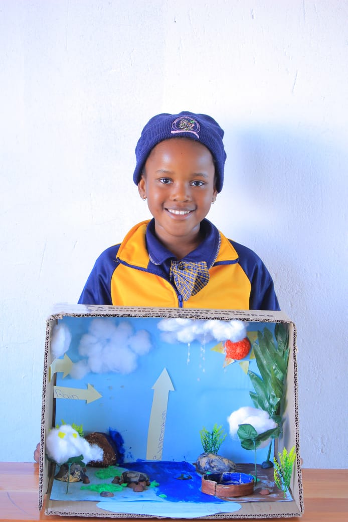 Learner presenting a water cycle diorama in a box