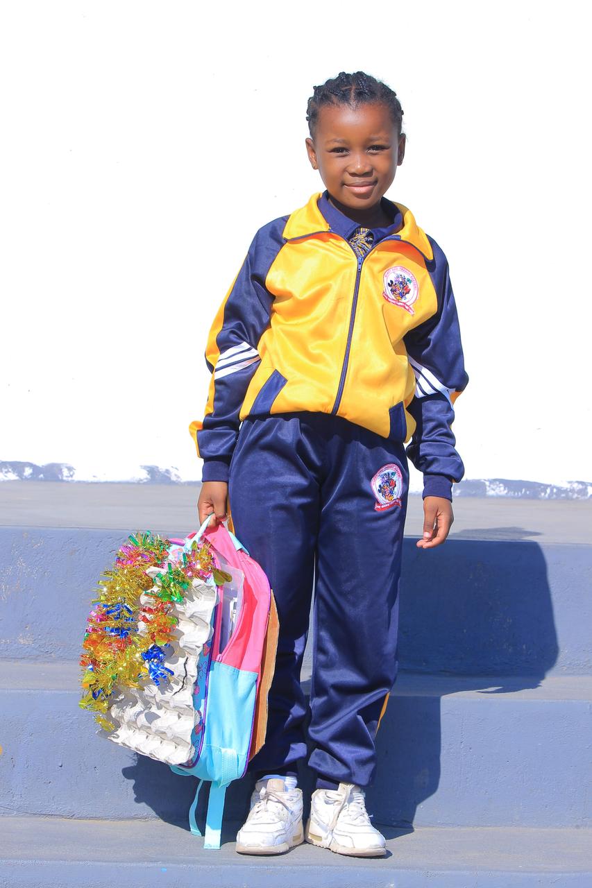 Learner with a tinsel-trimmed egg carton school bag