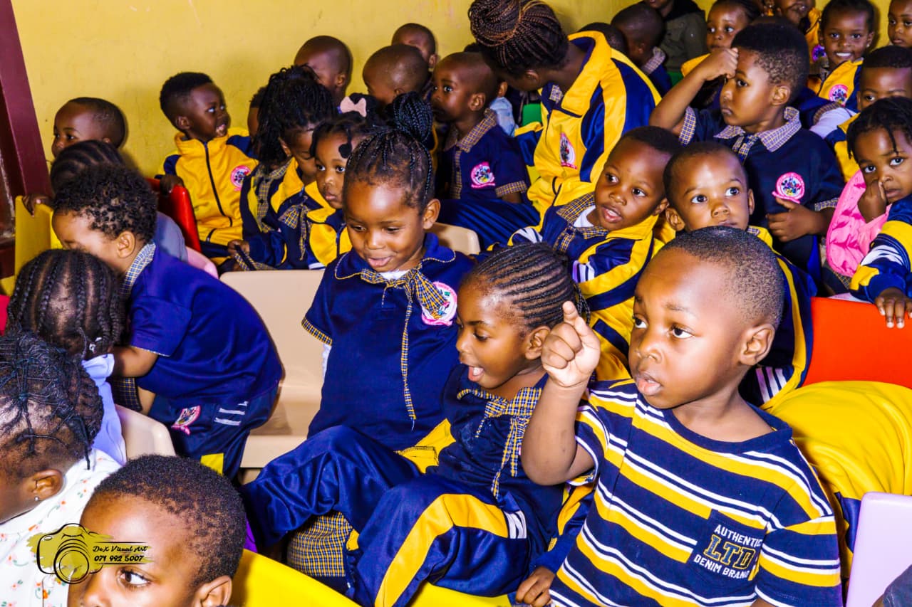Young learners smiling and laughing during the puppet performance