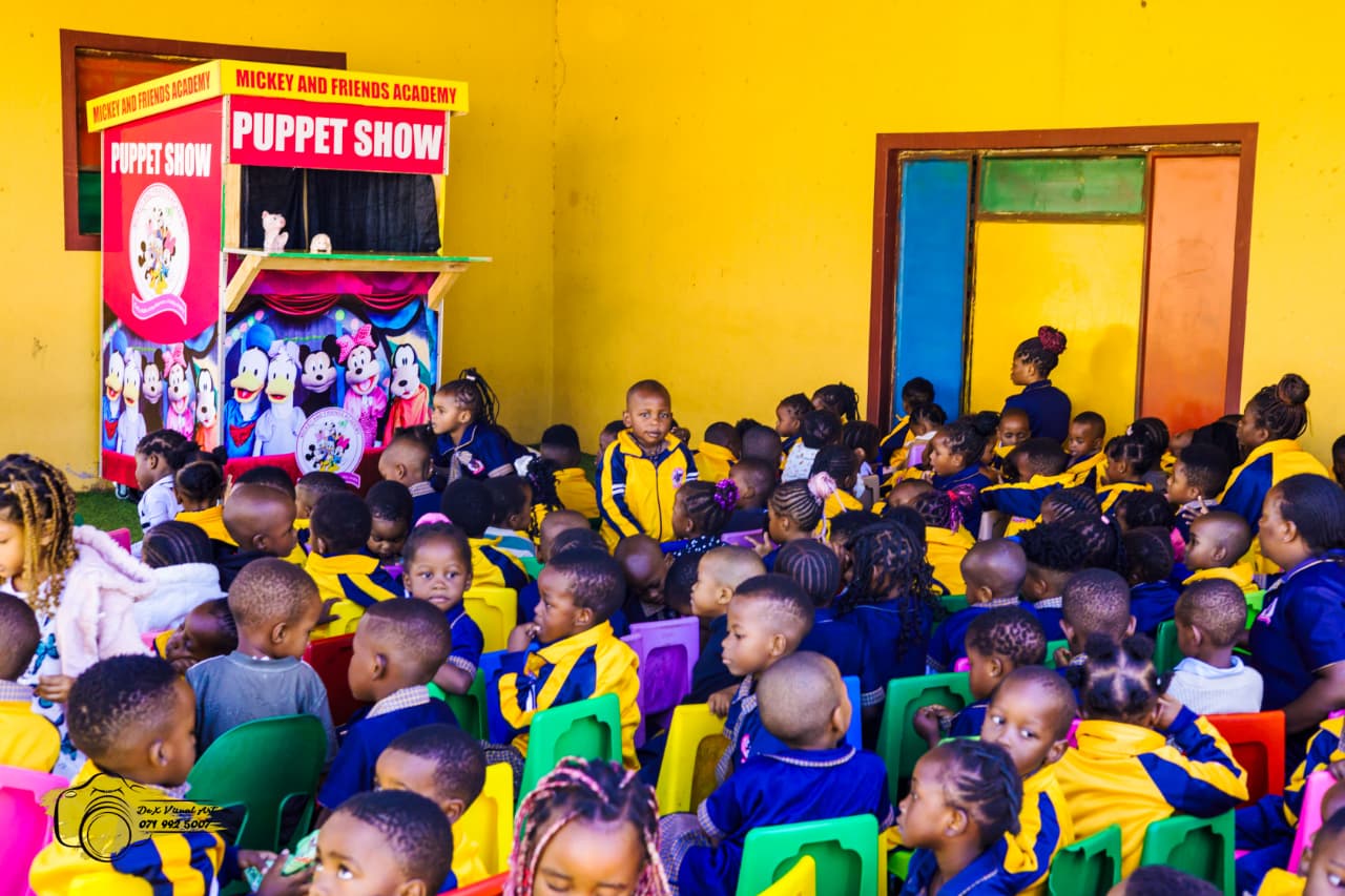 Creche learners seated in front of the puppet theatre watching the show