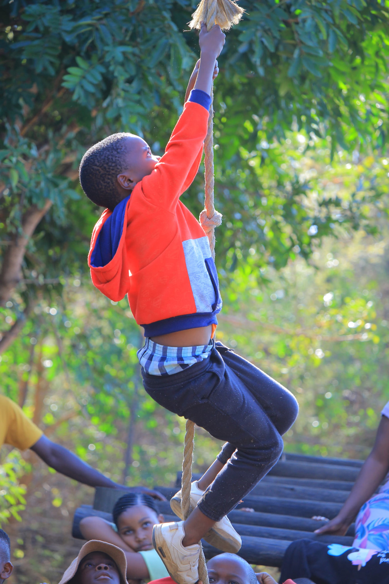Boy climbing a rope during a camp obstacle challenge