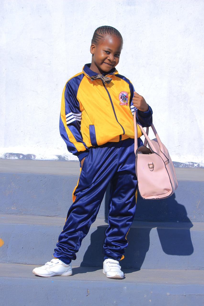 Pupil in tracksuit posing with a pink funky handbag
