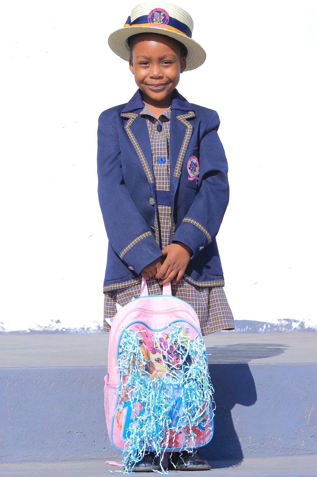 Smiling girl with a pink backpack trimmed in blue streamers