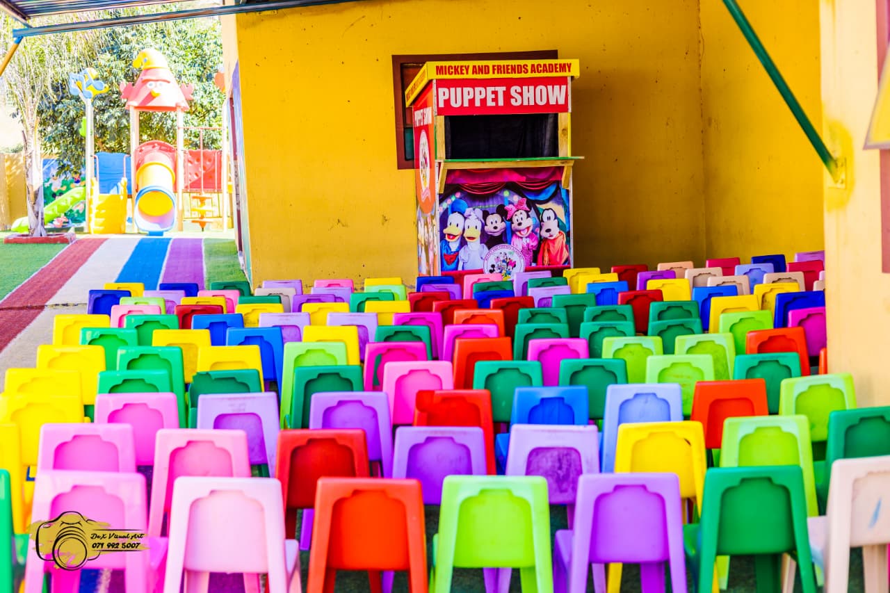 Colourful chairs set out in front of the puppet show stage