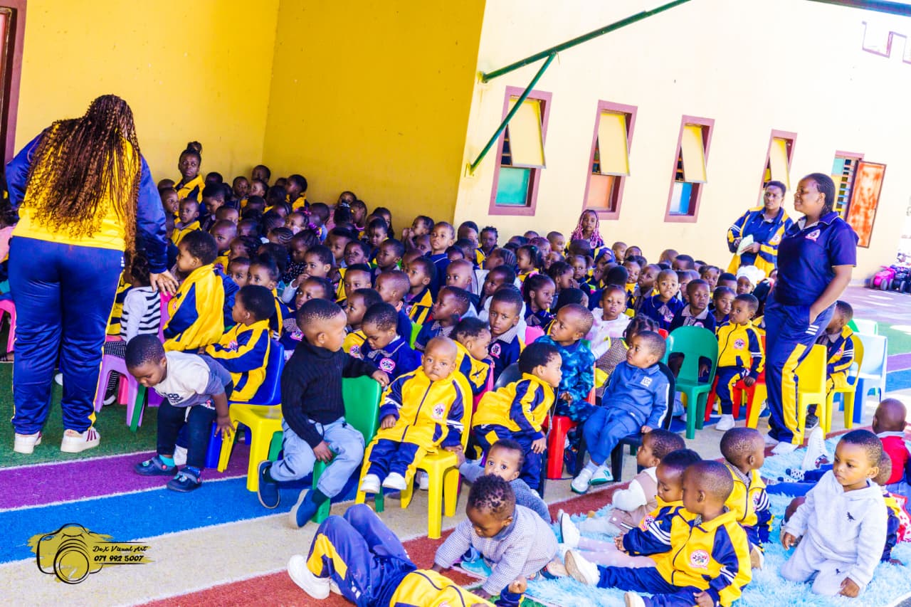 Teachers with a large group of creche learners at the outdoor puppet show