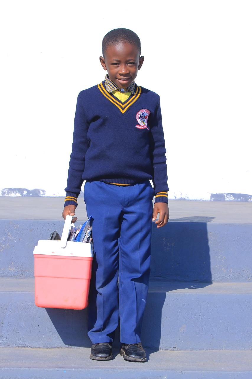 Boy carrying his books in a bright cooler box bag