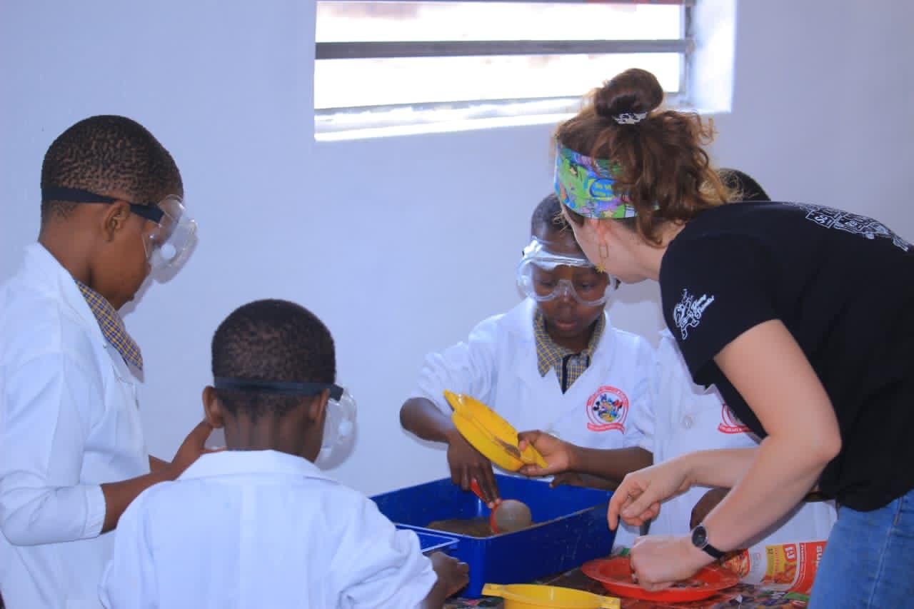 Science teacher guiding learners through a hands-on sand and water experiment