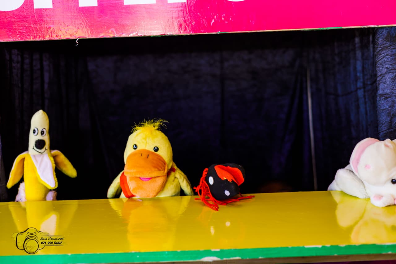 Duck and dog puppets peeking over the puppet theatre counter